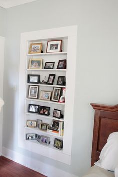 a white book shelf filled with books next to a fireplace