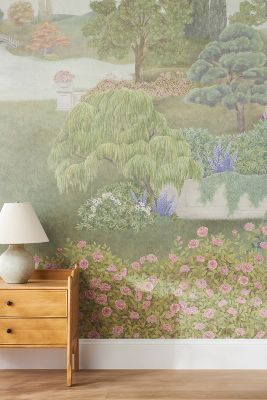 a room with a dresser, lamp and painting on the wall behind it that has pink flowers