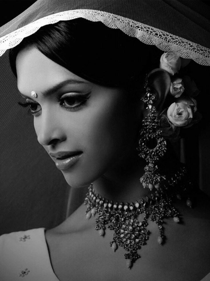 black and white photograph of a woman with jewelry on her head, wearing a veil