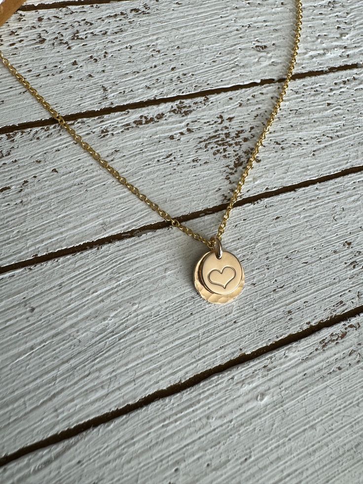 The sweetest necklace ever….featuring a hand stamped heart set on a larger stamped disc and a dainty chain, this little beauty goes with everything! Material is 14k gold filled. Chain measures 16” Handmade at the time you order. Dainty Stamped Charm Necklaces For Mother's Day, Dainty Stamped Charm Necklaces For Everyday, Dainty Hand Stamped Charm Necklaces For Everyday, Dainty Hand Stamped Charm Necklace For Everyday, Dainty 14k Gold Filled Engraved Charm Necklaces, Dainty 14k Gold Filled Hand Stamped Necklace, Dainty Hand Stamped 14k Gold Charm Necklaces, Dainty Hand Stamped Round Disc Necklaces, Dainty Hand Stamped 14k Gold Necklace