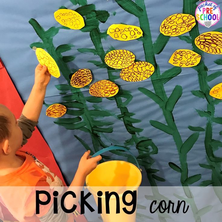 a young boy is painting flowers on a wall with green leaves and the words picking corn