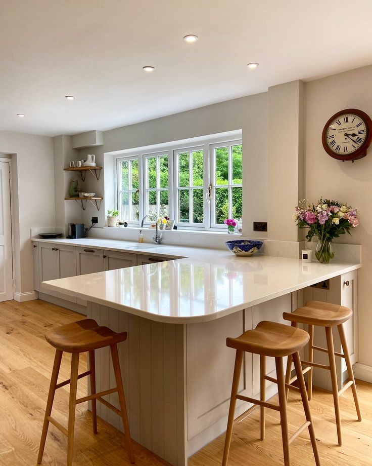 a kitchen with an island and three stools in front of the counter top area