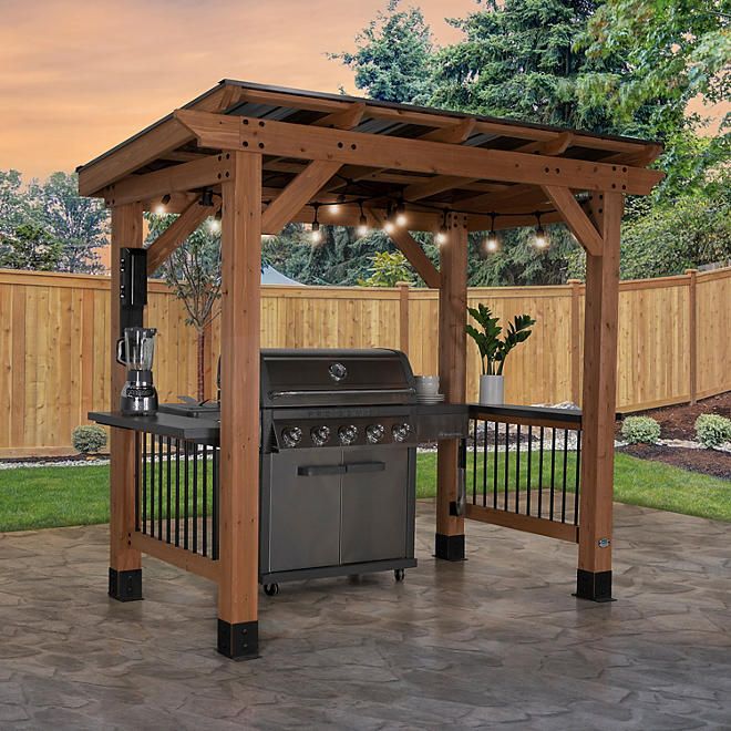 an outdoor bbq with grill and lights on it