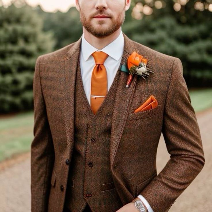 a man in a suit and orange tie with an orange boutonniere on his lapel