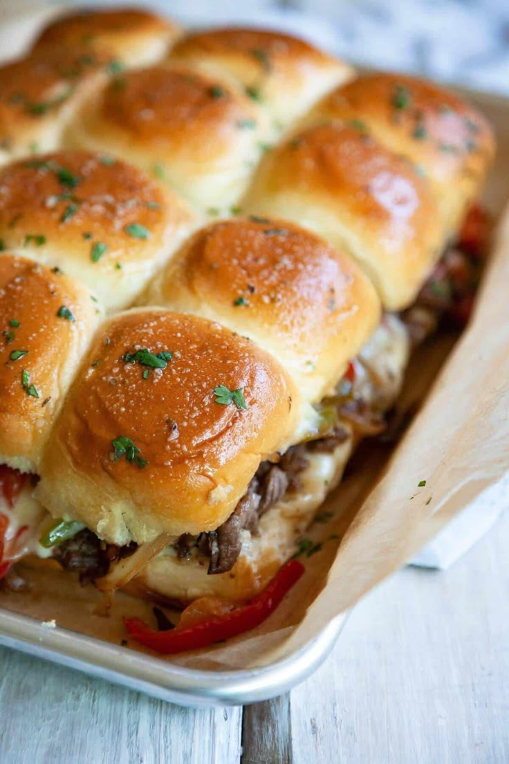 a casserole dish filled with sliders and cheese