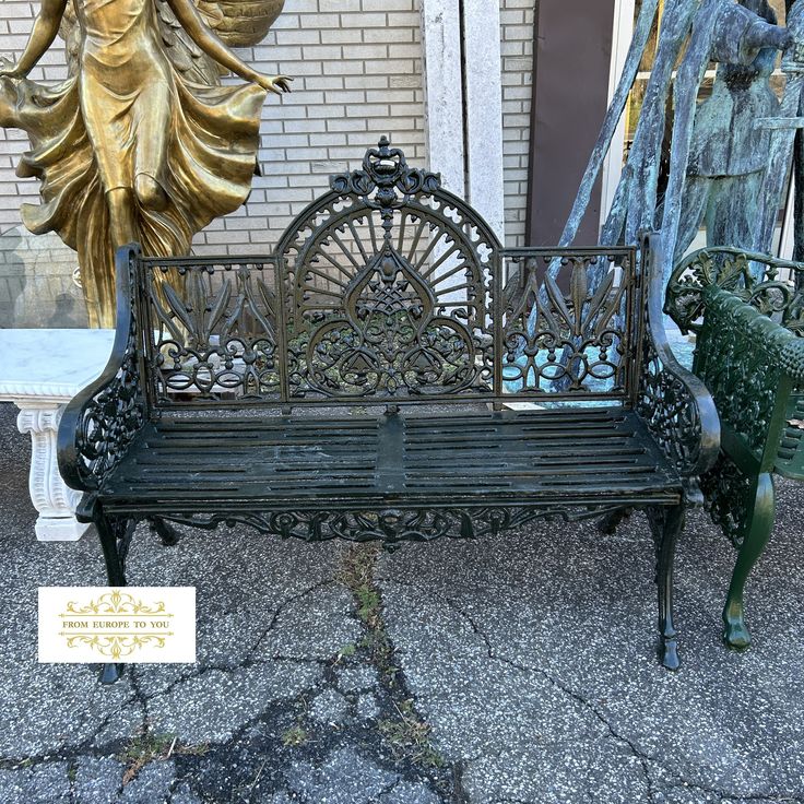 a bench sitting on top of a sidewalk next to a statue