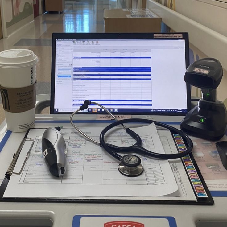 a laptop computer sitting on top of a desk next to a stethoscope