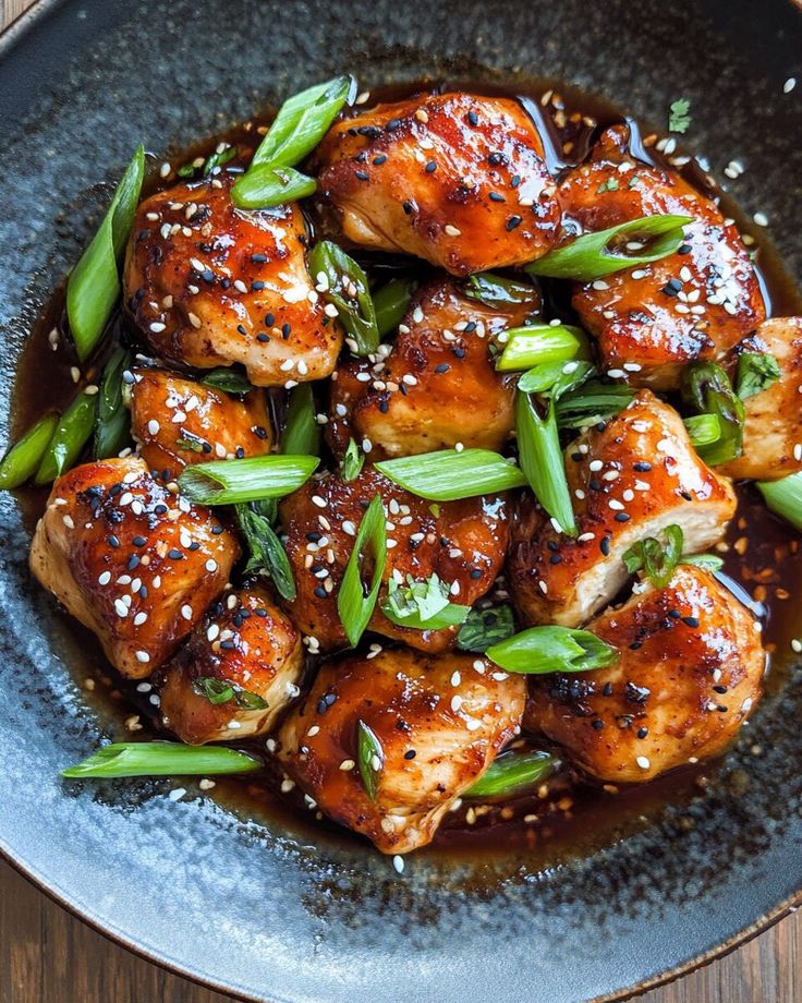 sesame seed chicken with green beans and sesame seeds in a brown sauce on a blue plate