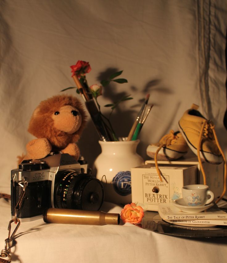 a stuffed animal sitting on top of a table next to a camera and other items