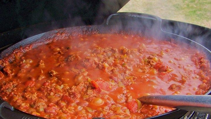 a large pot filled with lots of food cooking on top of a bbq grill