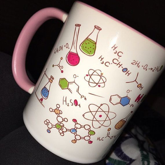 a pink handle on a coffee mug with science symbols and beakers painted on it