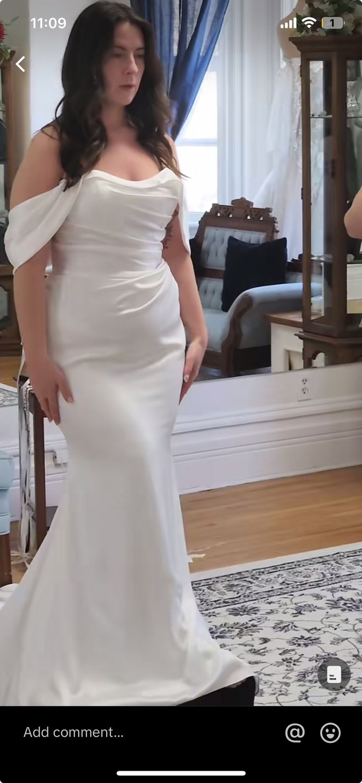 a woman in a white dress is standing near a mirror