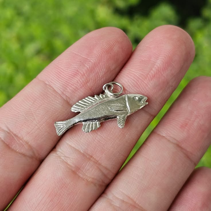 This is a Sterling silver fish pendant/charm. This pendant is a hand poured item. Please be mindful that hand poured items may have variations and sligtht imperfections which adds to the character and uniqueness. This pendant is in excellent condition this would make a great addition to any jewelry lovers collection.  **JUST THE FACTS** Fish Pendant Sterling Silver 925 Weight: 0.8 DWT / 1.2 Grams Bail Diameter: 2mm round Excellent Condition - hand poured new To see more related products from our 1920s Jewelry, Fish Jewelry, Fish Pendant, Silver Fish, Filigree Pendant, Be Mindful, Dope Jewelry, Funky Jewelry, Dream Jewelry