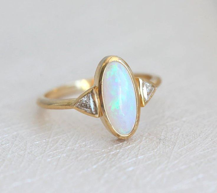 Best seller at Capucinne - Gorgeous one of a kind Australian oval opal & diamond ring perfect as a wedding or engagement ring. Available in 18k yellow gold as seen online. If you would like to have other gemstones instead of diamonds/opals Luxury Classic Opal Ring With Center Stone, Heirloom Oval Opal Ring With Multi-stone, Oval Opal Ring With Rose Cut Diamonds, Heirloom Opal Ring With Diamond In Oval Shape, Elegant Ethiopian Opal Ring With Oval Cabochon, Heirloom Diamond Opal Ring Oval Shaped, Heirloom Oval Opal Ring For Anniversary, Heirloom Oval Opal Ring With Diamond Accents, Heirloom Oval Opal Ring With Accent Stones