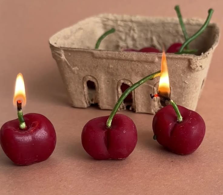 three cherries sitting next to each other in front of a basket