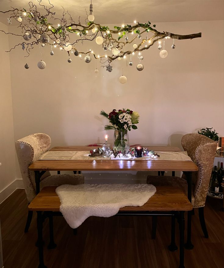 a dining room table with lights hanging from the ceiling