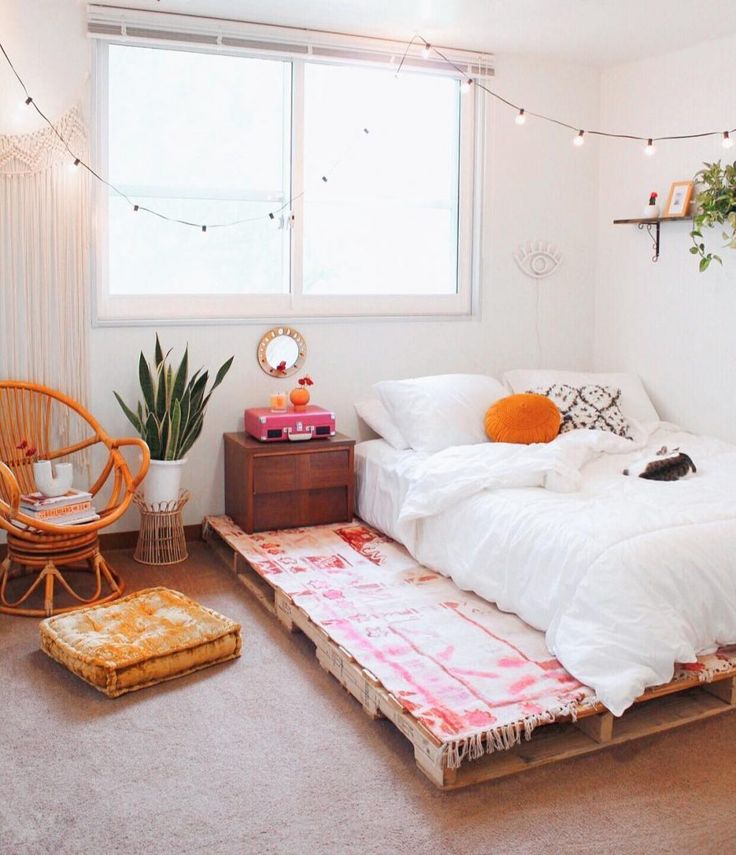 a bed with white sheets and pillows on top of it in a room next to a window