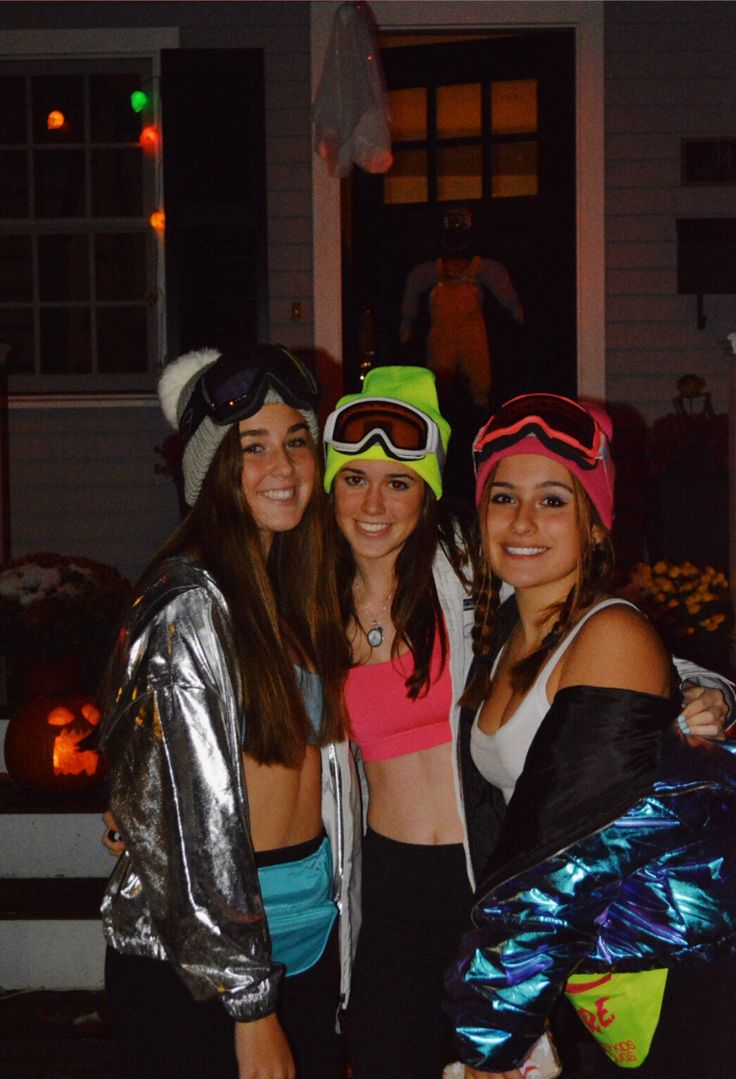 three young women dressed up in costumes posing for the camera at halloween time with their ski gear and goggles on