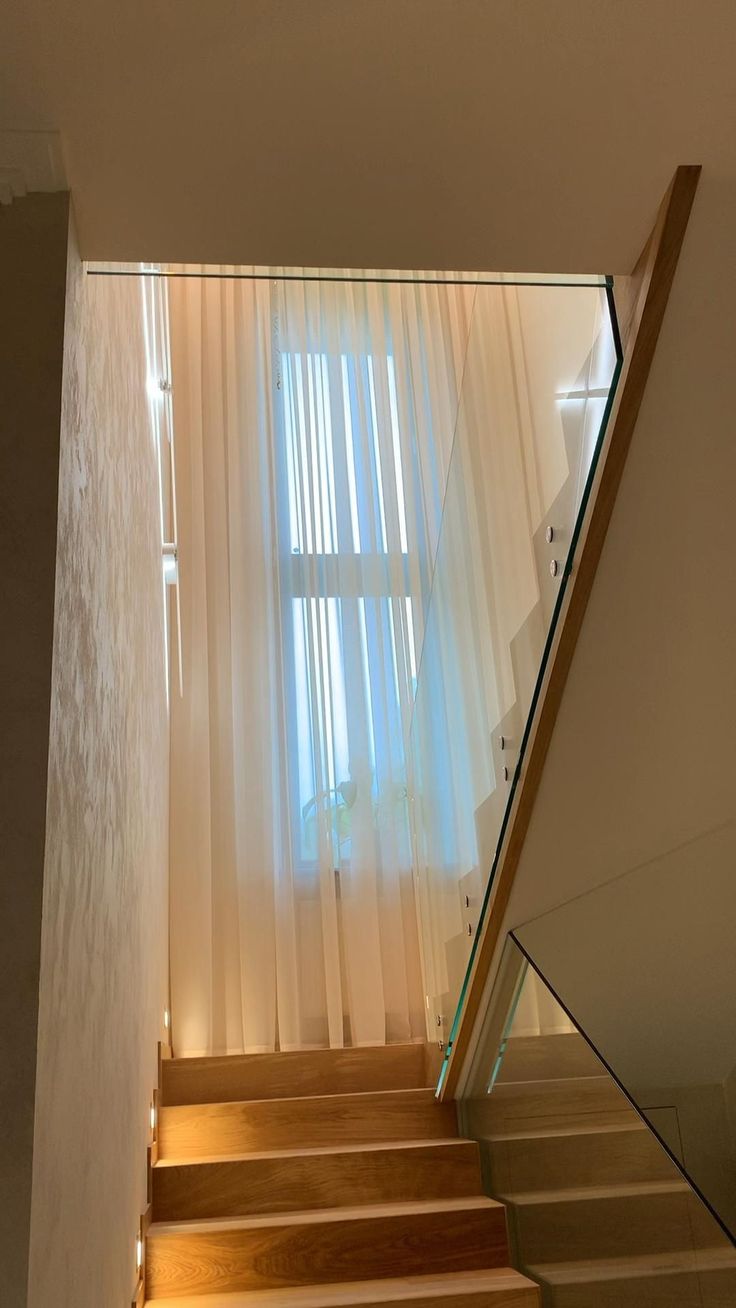 stairs leading up to a window with sheer curtains