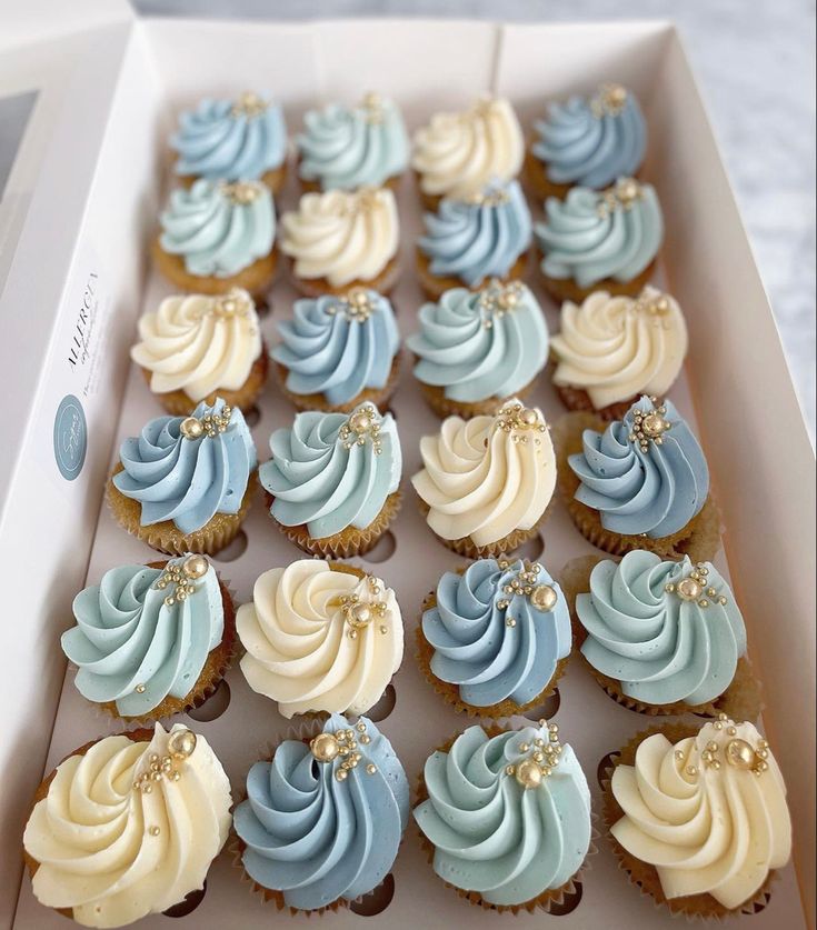 a box filled with blue and white cupcakes