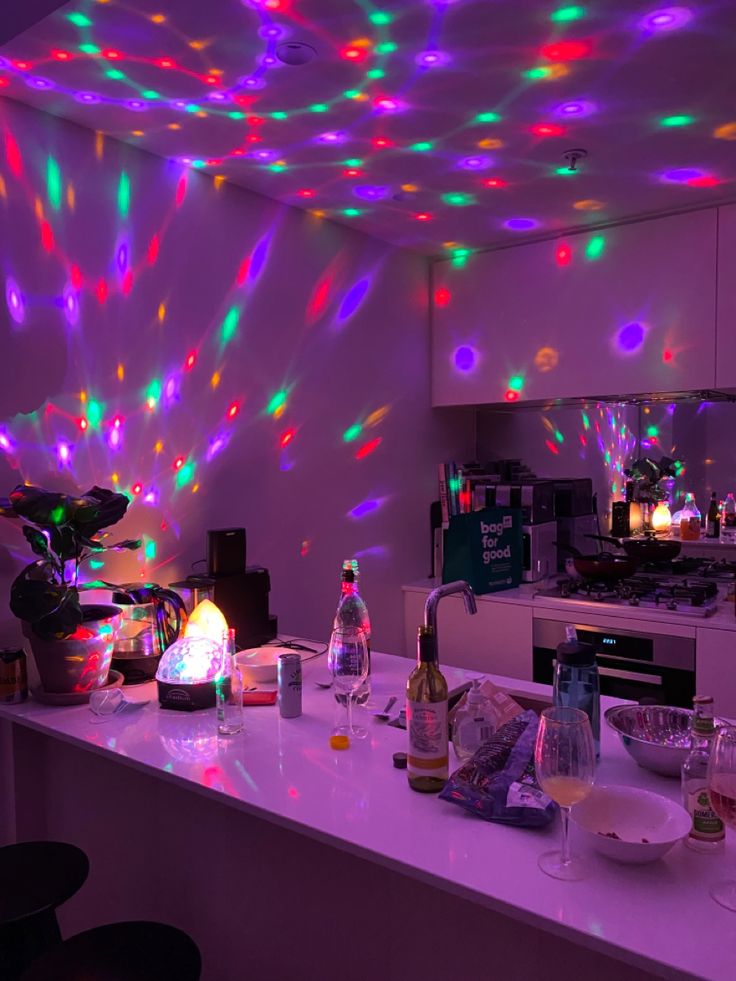 a room with lights on the ceiling and various bottles sitting on the counter in front of it