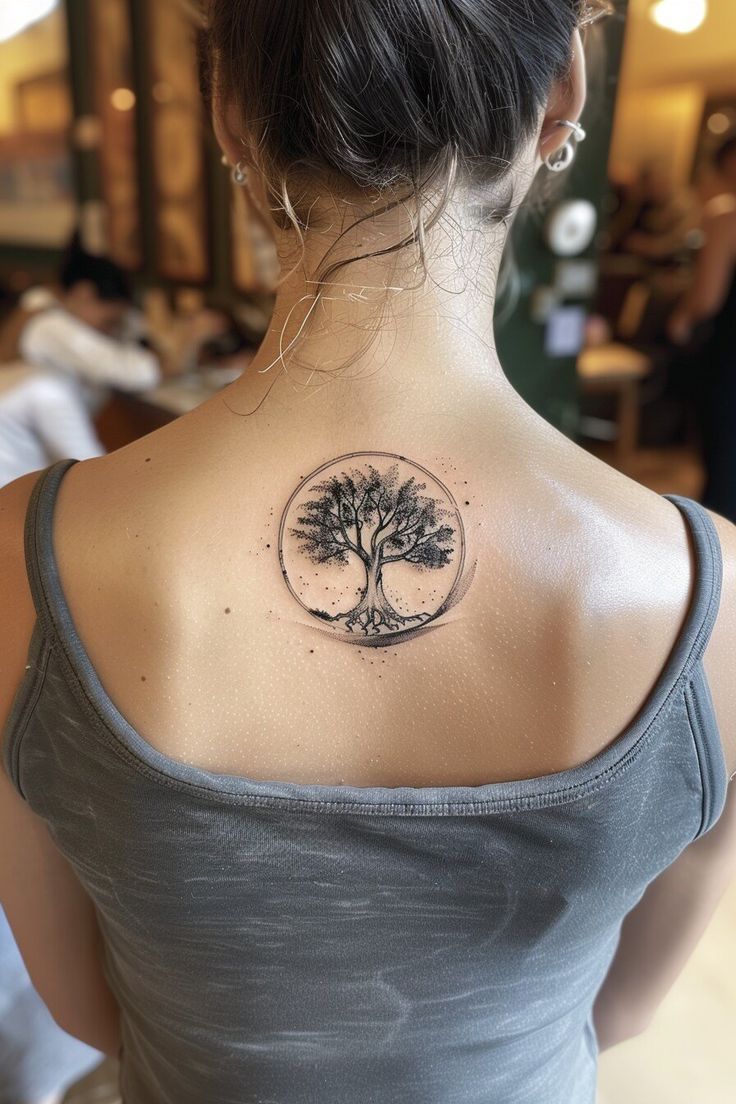 a woman with a tree tattoo on her back