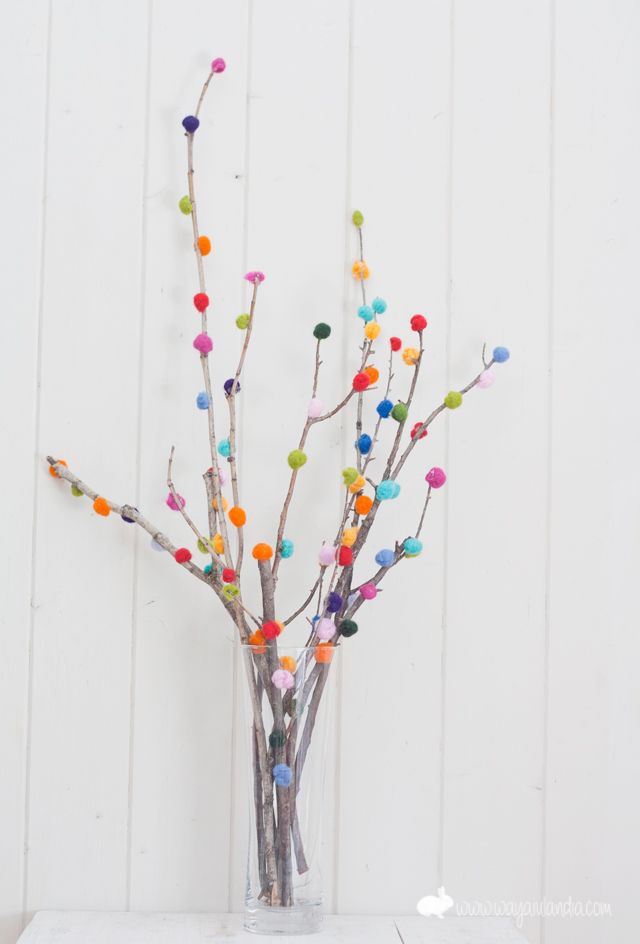 a vase filled with colorful balls and branches