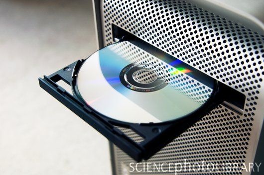 a cd is sitting on top of a metal object with perforated mesh covering it