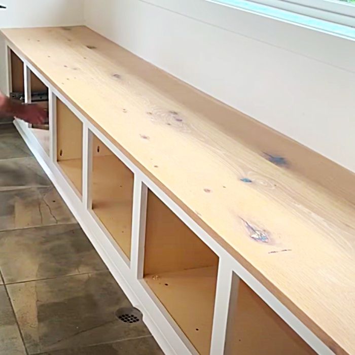 a man is standing next to a shelf with shelves on each side and the floor below it