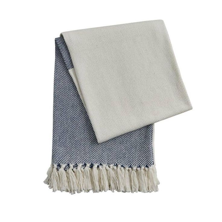 two blue and white towels folded on top of each other, one with fringes