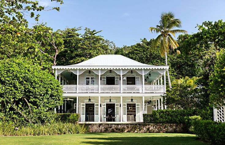 a large white house surrounded by lush green trees