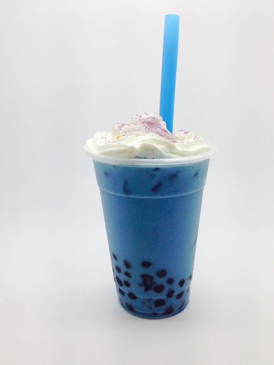 a blue drink with whipped cream and sprinkles in it on a white background