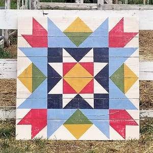 a wooden fence with a colorful quilt on it