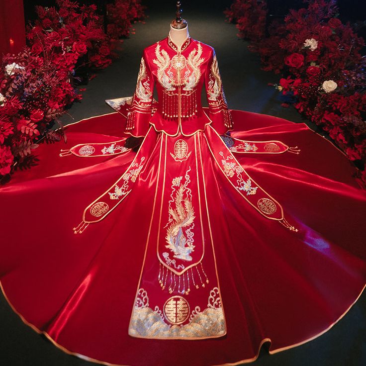 This stunning Qun Kwa is a traditional Chinese wedding dress, featuring a rich red color that symbolizes good luck, happiness, and prosperity. The dress is intricately embroidered with golden phoenix motifs, which are symbols of femininity, grace, and harmony in Chinese culture. Made from satin fabric, ensuring both comfort and elegance. Pair it with a dragon tang suit (ma gua), representing the perfect balance between yin and yang Size Guide: Please refer to the size guide picture before placin Traditional Ceremony Gown For Festivals, Red Floor-length Gown For Traditional Ceremonies, Traditional Wedding Dress For Ceremonies, Traditional Embroidered Wedding Dress For Festive Season, Traditional Festive Dress With Long Train, Traditional Red Gown With Long Sleeves, Traditional Dress With Long Train For Festive Occasions, Traditional Red Long Sleeve Gown, Traditional Long Sleeve Red Gown