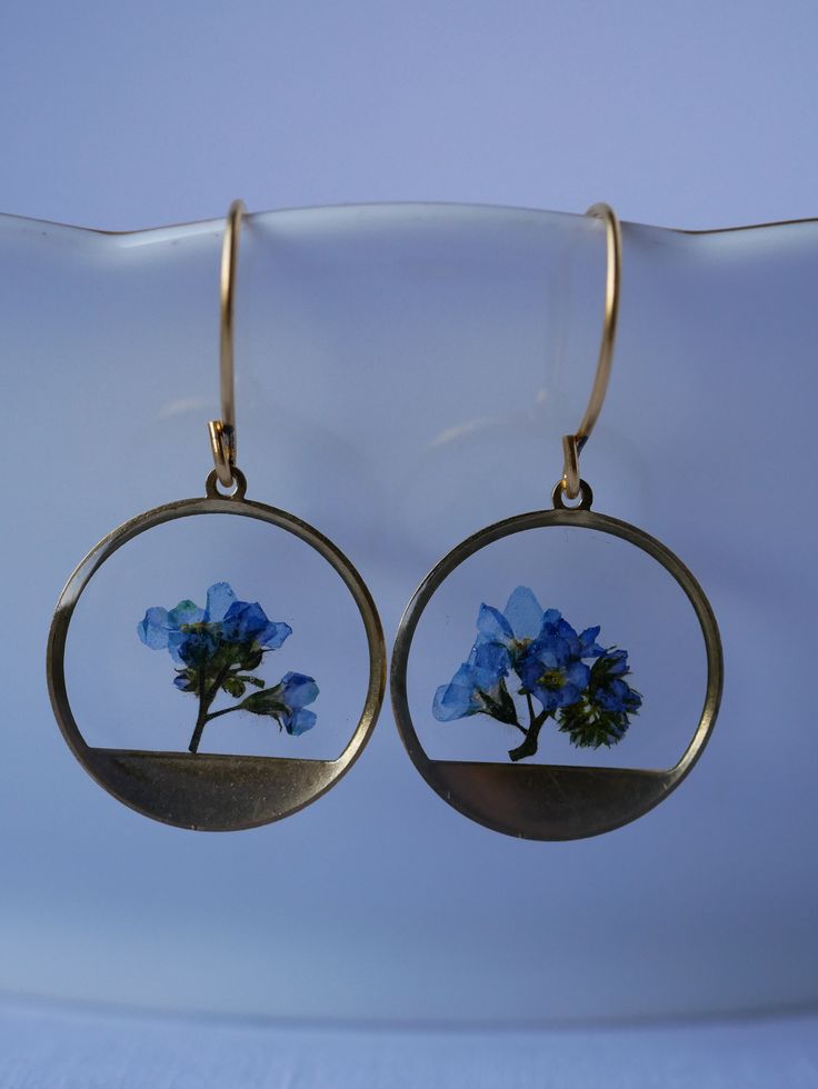 These small round brass frames that are evocative of the sun on the horizon hang from 24k gold plated ear hooks. Available in your choice of real preserved botanical: Queen Anne's Lace is a symbol of sanctuary The Daisy is a symbol of hope Forget-me-nots are known as a symbol of lasting friendship, love, and remembrance Materials are tarnish resistant. However, please see our care section for info on keeping your piece lovely for years to come. All materials are nickel and lead free. Ships in a Nature-inspired Nickel Free Round Earrings, Nickel-free Round Nature-inspired Earrings, Handmade Nature-inspired Round Hoop Earrings, Pierced Round Recycled Gold Jewelry, Round Recycled Gold Pierced Jewelry, Recycled Gold Round Jewelry, Nature-inspired Hoop Earrings As Gift, Nature-inspired Round Hoop Earrings For Gift, Pierced Round Recycled Gold Earrings