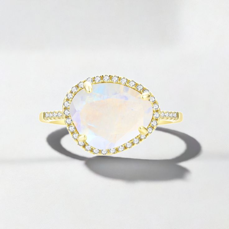 The Skye Moonstone Ring features a genuine Rainbow Moonstone surrounded by a halo of crystals on a pave band. Available in 14k Gold Vermeil or Sterling Silver. Rainbow Moonstone is a naturally occurring gemstone. Each one is beautiful and unique in its own way. These stones all many have variations in clarity, clouds and striations. Fine Jewelry Moonstone Ring With Diamond Halo, Fine Jewelry Diamond Moonstone Ring With Halo, Moonstone Diamond Ring With Halo Setting, Elegant Crystal Ring With Gemstone Accents As Promise Ring, Elegant Crystal Promise Ring With Gemstone Accents, Elegant Crystal Ring With Gemstone Accents For Promise, Elegant Crystal Ring With Gemstone Accents, Dazzling Diamond Ring With Gemstone Accents For Wedding, White Gold Crystal Diamond Ring With Gemstone Accents