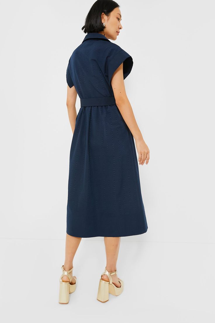 Elegant in its simplicity, the structured and ultra-ladylike Navy Chloe Dress is done in a textured cotton-blend fabric that is sure to turn heads for its design details. The moire pattern throughout and trapunto stitching on the sleeves, placket, and hemline complete this midi moment, making it feel extra special with minimal effort. Pair with heels or flats, sunnies or statement earrings, for day or night, and rest assured that you look fabulous! Spread collar Short wing sleeves Button front p Modern A-line Cotton Dress, Modern Cotton A-line Dress, Chic Cotton Dresses With Pleated Waist, Elegant Cotton Dress With Pleated Waist, Chic Cotton Dress With Pleated Waist, Modern Cotton Dresses For Daywear, Cotton Dresses With Pleated Sleeves For Daywear, Modern Cotton Daywear Dress, Elegant Cotton Midi Dress With Pleated Sleeves