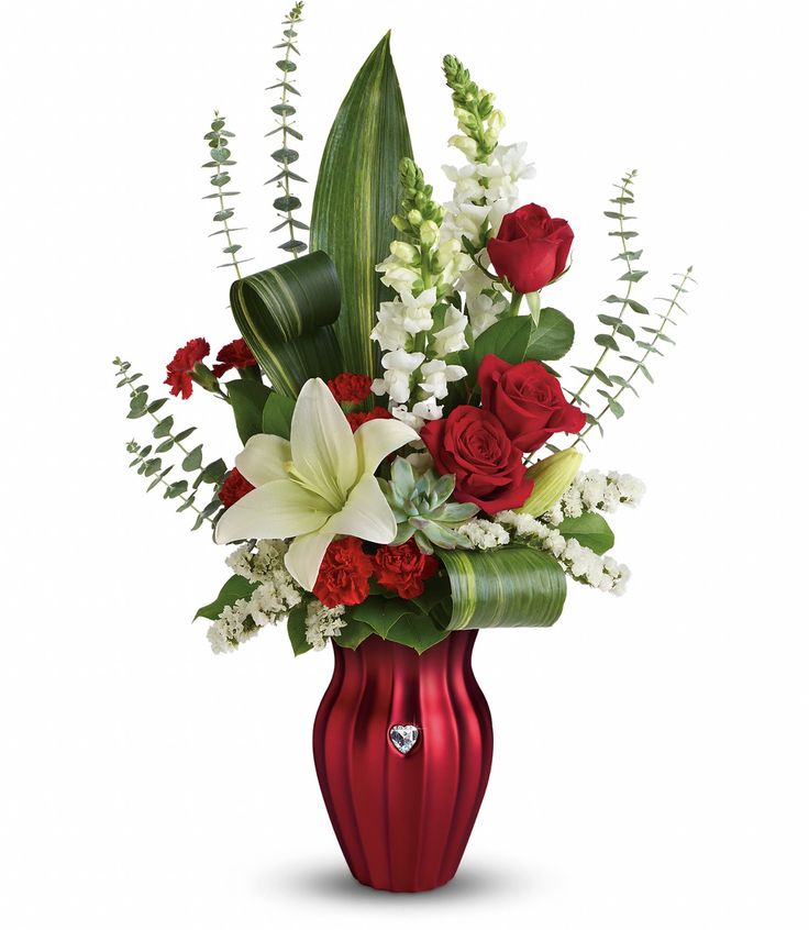 a red vase filled with white and red flowers