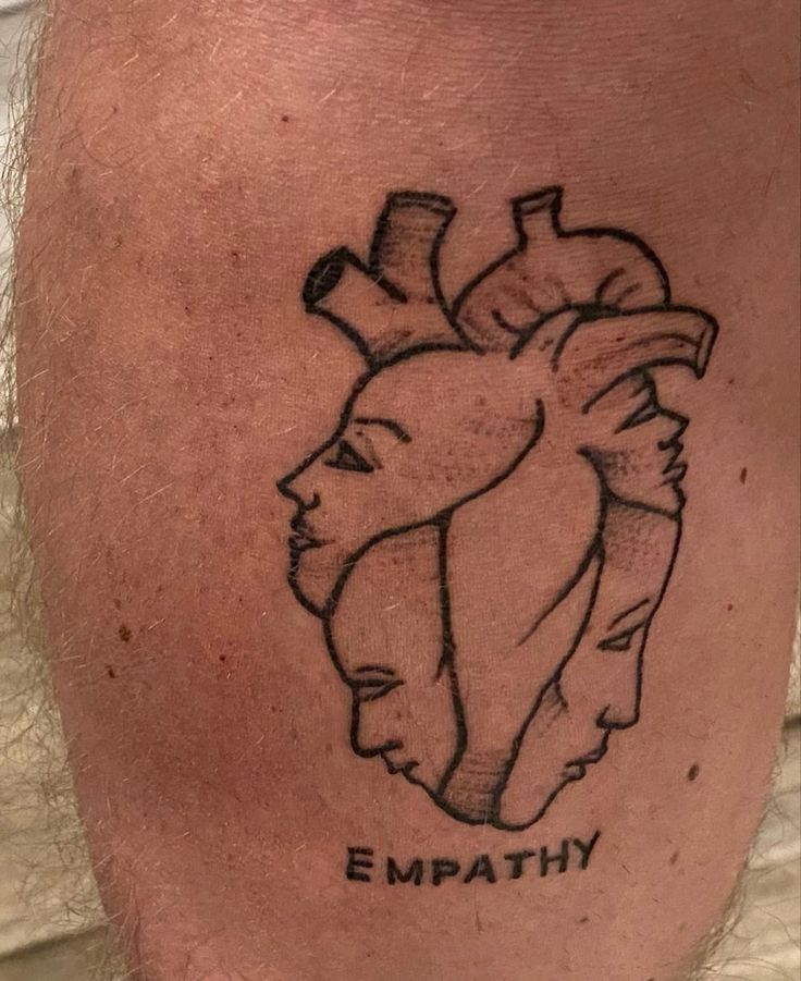 a man with a tattoo on his leg that says, empathy and an image of a heart