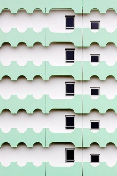 the side of a green building with several windows