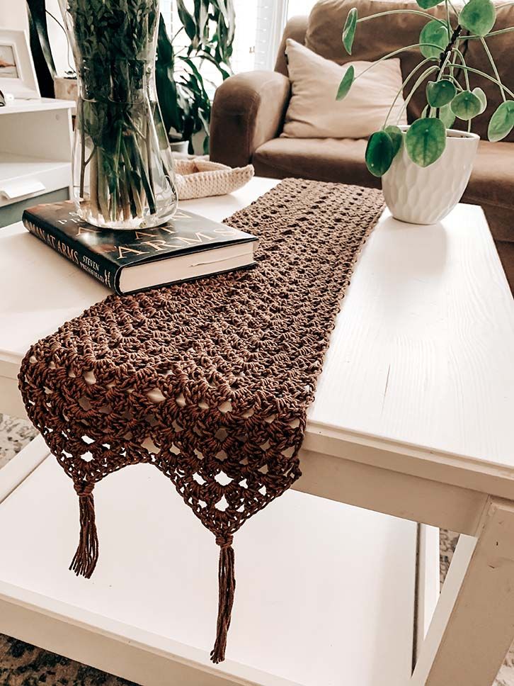 a coffee table with a crocheted runner on it