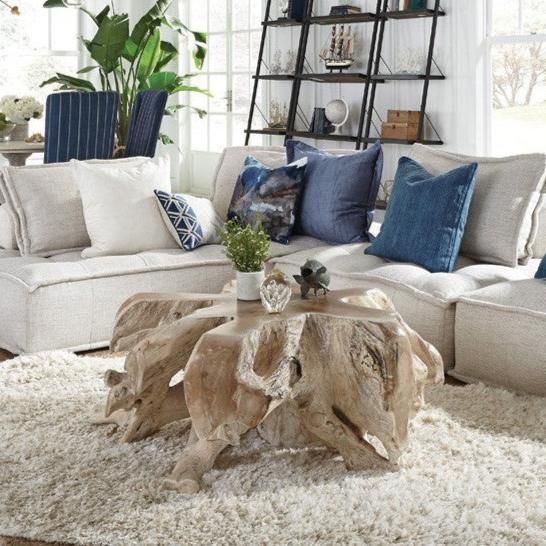 a living room filled with lots of furniture and pillows on top of a white rug