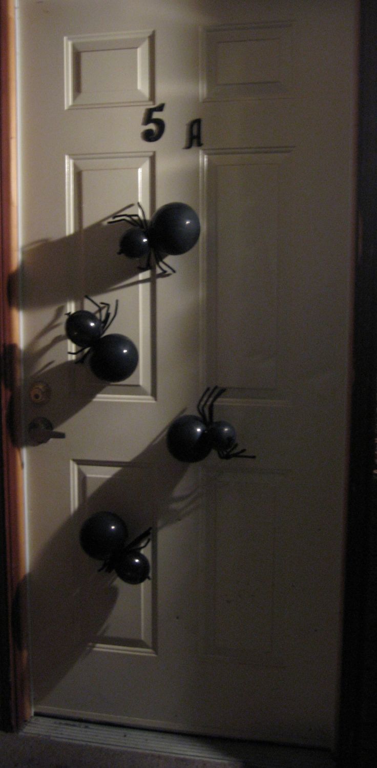 the door is decorated for halloween with black balls and spider webs hanging from it