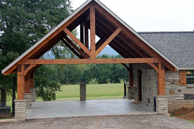 an outdoor pavilion with stone pillars and wood beams