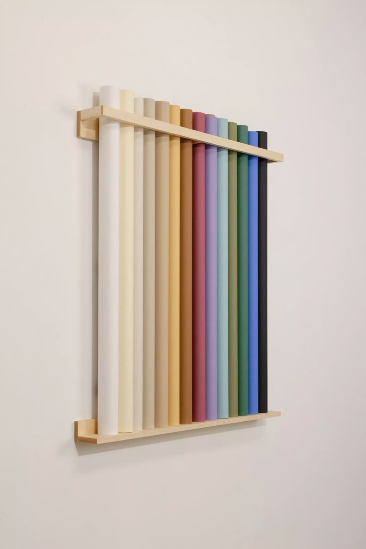 a wall mounted shelf filled with different colored papers