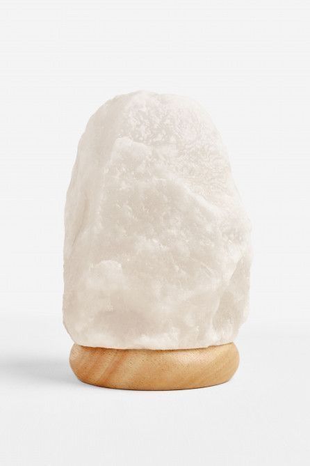 a white rock sitting on top of a wooden stand