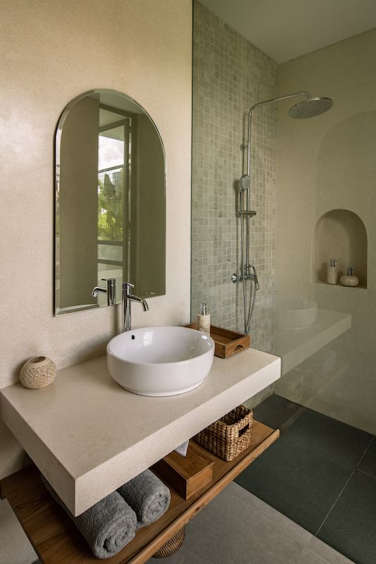 a bathroom with a sink, mirror and shower stall in it's center area