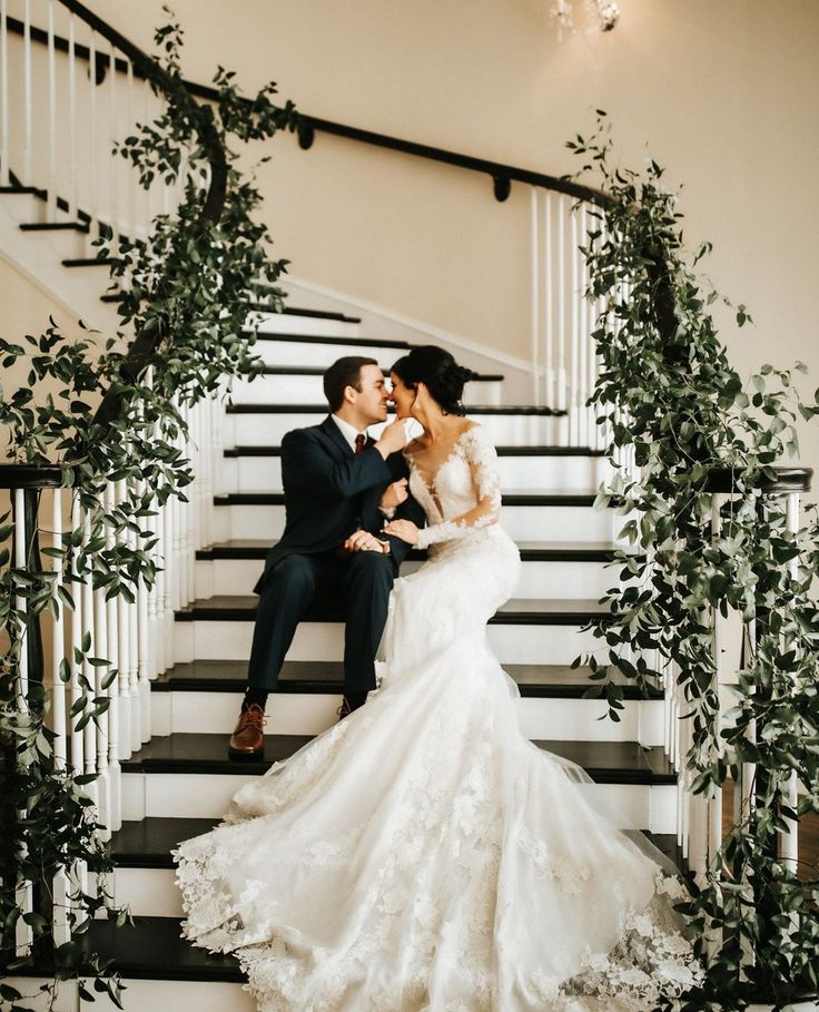 a bride and groom are sitting on the stairs