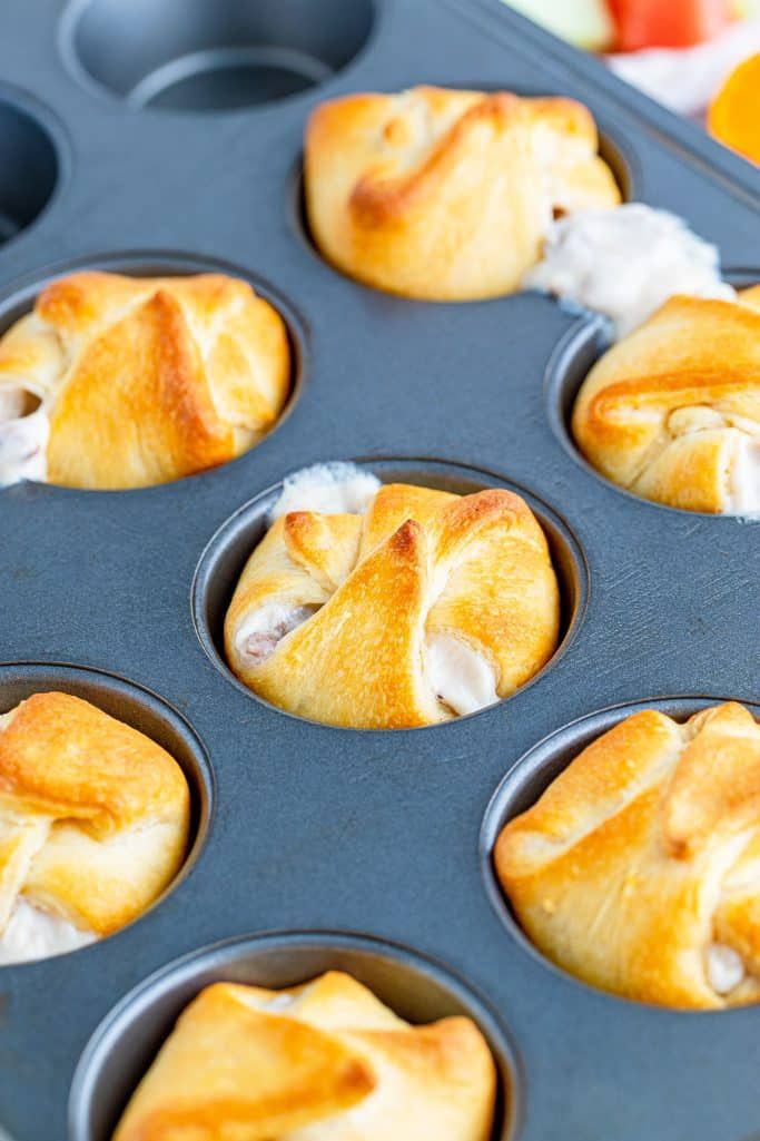 muffins in a pan with white icing and orange juice on the side