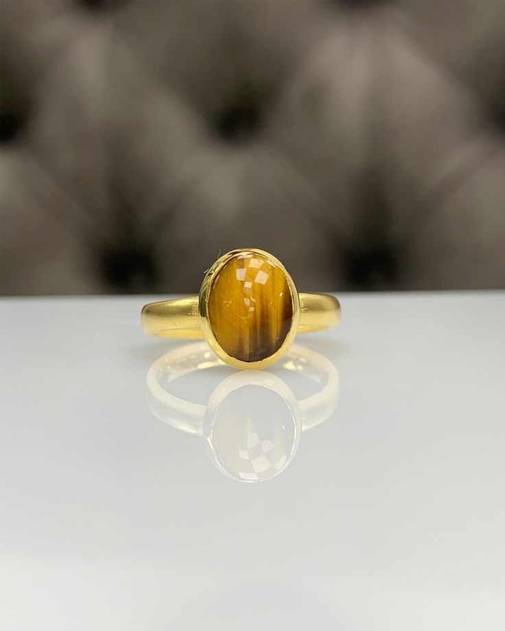 Natural Tiger Eyes Ring * Dainty Cabachon Ring * Genuine Tiger Eyes & 14K Solid Gold * Best Gift for Her/Him * Handmade Ring ◎ Details ◎ ○ Gemstone Details .Natural TIGER EYES Oval Cut 10x8 mm approx. 2.00 ct ○ Gold Details 14K Solid Gold Width of Band : 2.50 mm Weight of Ring : approx 3.80 gr Made to Order HANDMADE ITEM ○ Upgrade to Solid 18K Gold, please click the link below: https://www.etsy.com/listing/962826004 For more CABACHON BEZEL rings : http://etsy.me/37fvI60 All of our jewellerie Handmade 14k Gold Oval Cabochon Jewelry, 14k Yellow Gold Cabochon Ring, Gold Rings With Bezel Setting And Oval Cabochon, Gold Oval Cabochon Birthstone Ring, Gold Cabochon Ring Fine Jewelry, Handmade 14k Gold Oval Rings, Yellow Gold Rings With Oval Cabochon Gemstone, 14k Gold Cabochon Rings With Round Band, 14k Gold Cabochon Ring With Round Band